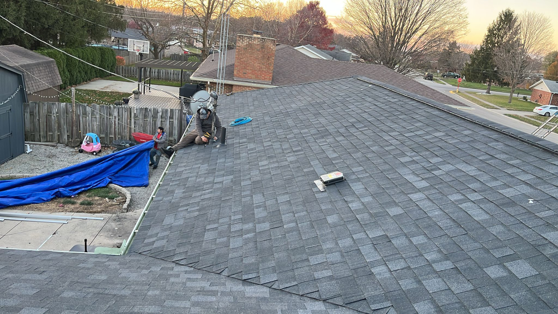 Crew installing new architectural shingles